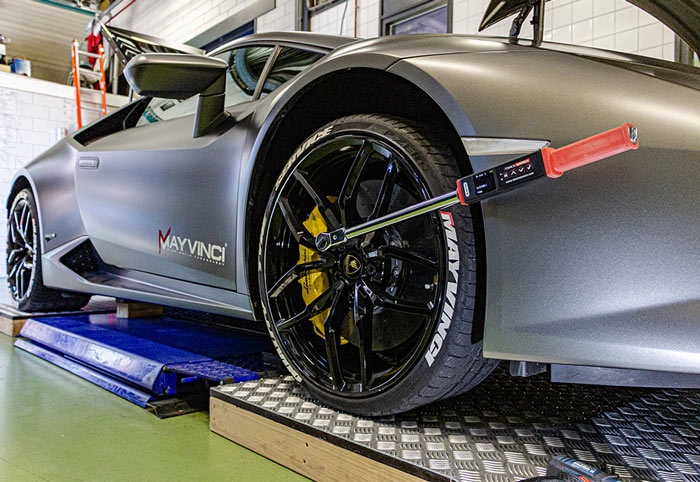 Torque wrench applied to a wheel hub on a car raised on a lift