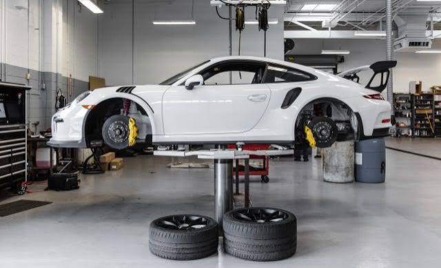 Porsche 911 raised on a workshop lift with wheels removed
