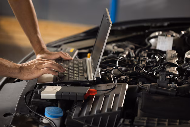 Diagnostic laptop connected to a vehicle during electronic analysis